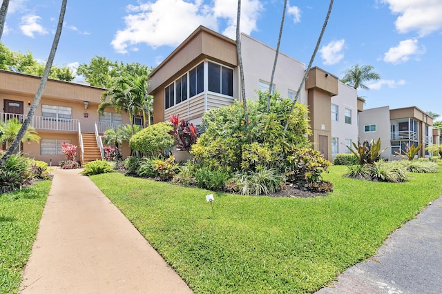 view of front facade with stucco siding and a front yard