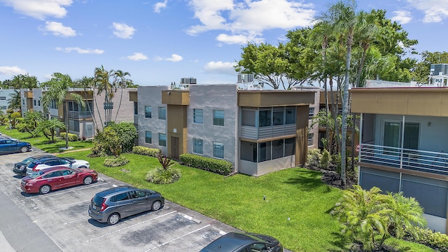 view of property featuring uncovered parking and central air condition unit