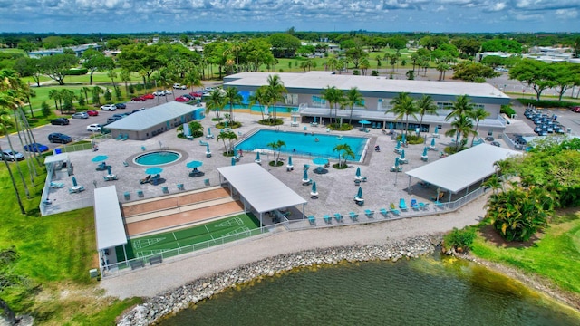 drone / aerial view of a pool area and a nearby body of water