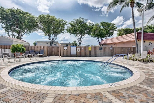 view of swimming pool with a patio, fence, and a swimming pool