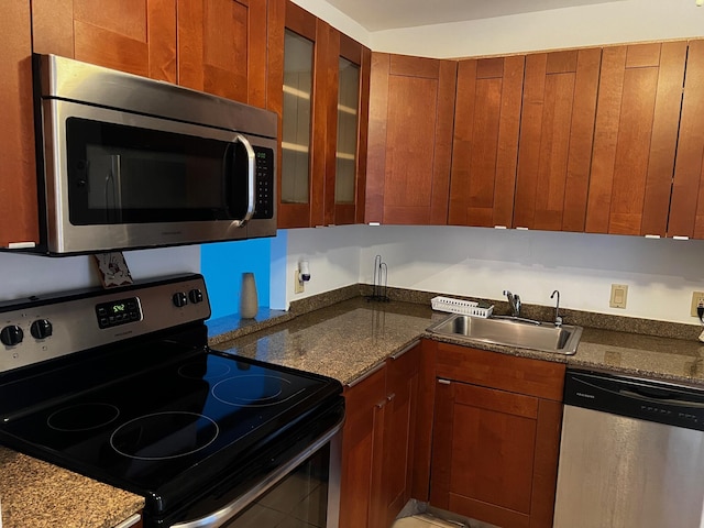 3101 N Country Club Dr Unit 510, Aventura, FL 33180 - kitchen featuring appliances with stainless steel finishes, a sink, glass insert cabinets, and brown cabinetry