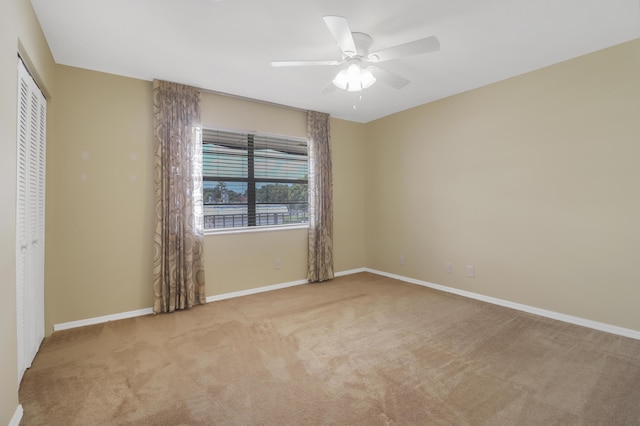 unfurnished bedroom with carpet floors, a closet, baseboards, and ceiling fan
