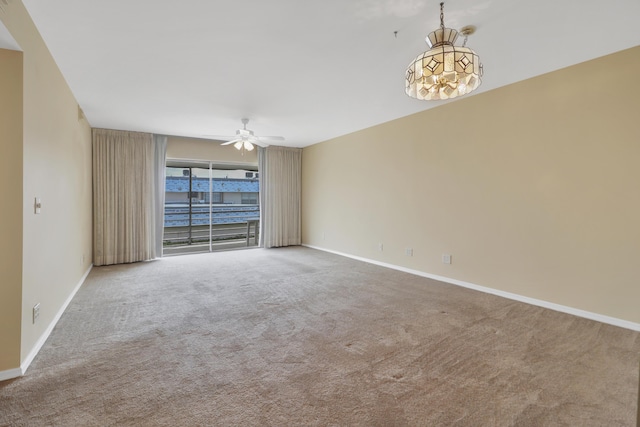 carpeted empty room featuring ceiling fan and baseboards