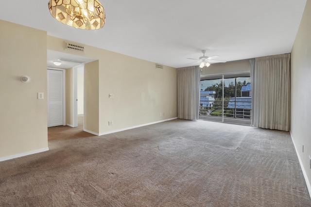 carpeted spare room featuring a ceiling fan and baseboards