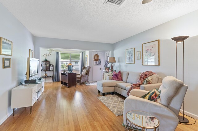 249 Cardinal Ln, Delray Beach, FL 33445 - living room featuring light wood finished floors, a textured ceiling, a ceiling fan, and baseboards
