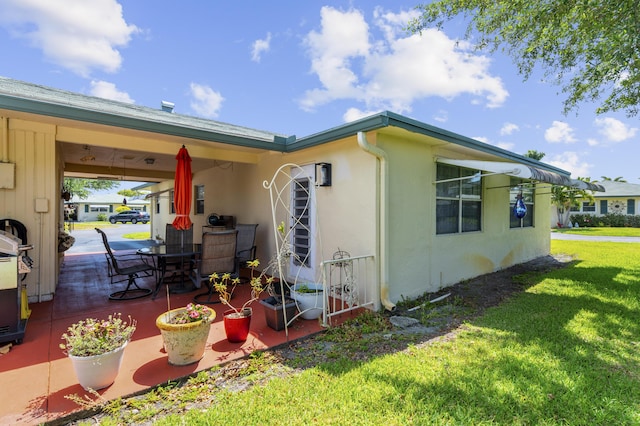 249 Cardinal Ln, Delray Beach, FL 33445 - view of home's exterior with a yard, stucco siding, and a patio area