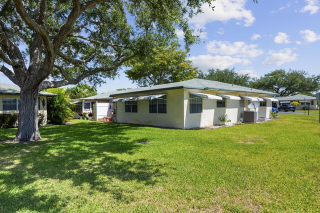 249 Cardinal Ln, Delray Beach, FL 33445 - rear view of property with central AC, a lawn, and stucco siding