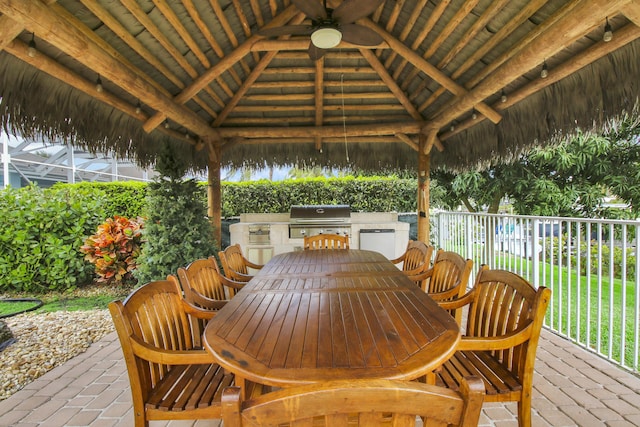 view of patio / terrace featuring exterior kitchen, a gazebo, a grill, and a ceiling fan