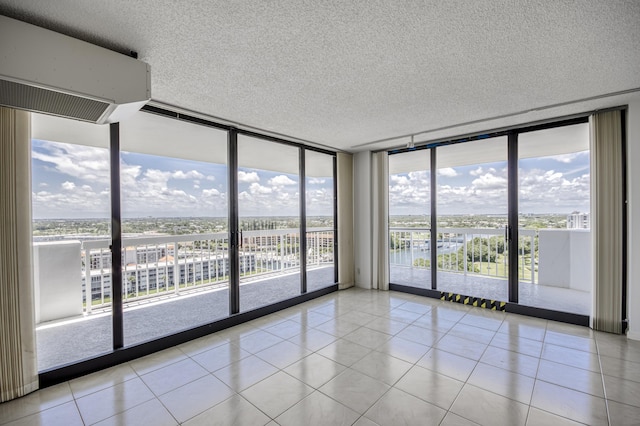 123 Lakeshore Dr Unit 1644, North Palm Beach, FL 33408 - unfurnished room with floor to ceiling windows, a textured ceiling, light tile patterned floors, a wall mounted air conditioner, and a water view