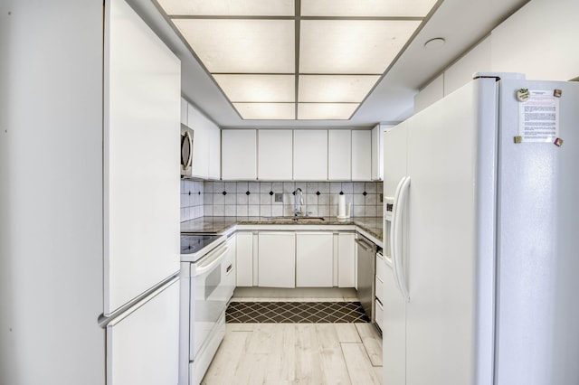 123 Lakeshore Dr Unit 1644, North Palm Beach, FL 33408 - kitchen featuring appliances with stainless steel finishes, a sink, white cabinets, decorative backsplash, and light wood-type flooring