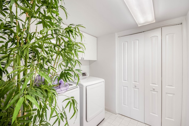 123 Lakeshore Dr Unit 1644, North Palm Beach, FL 33408 - laundry room with light tile patterned floors, cabinet space, baseboards, and washer and clothes dryer