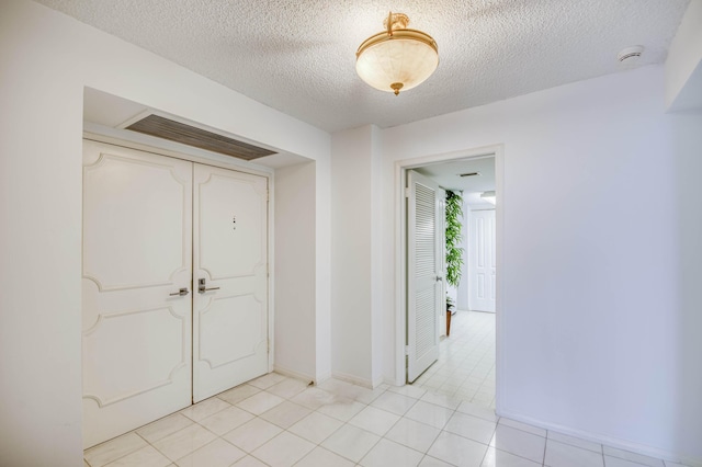 123 Lakeshore Dr Unit 1644, North Palm Beach, FL 33408 - foyer entrance with a textured ceiling, light tile patterned floors, and baseboards