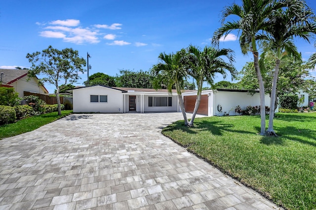 ranch-style house featuring decorative driveway and stucco siding
