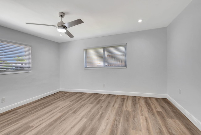 empty room with wood finished floors, baseboards, ceiling fan, and recessed lighting