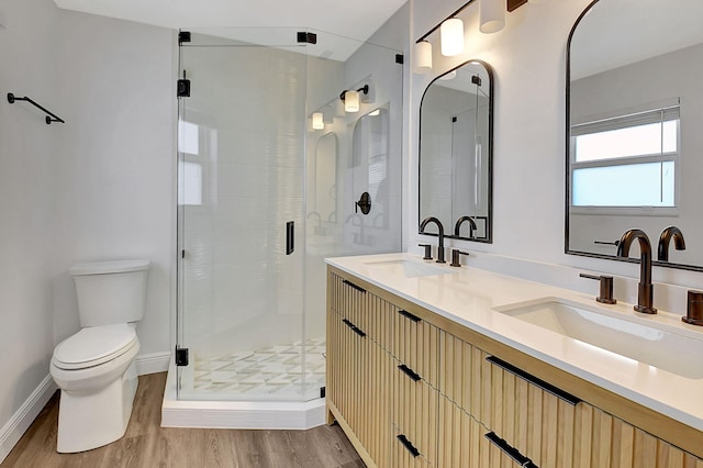 full bathroom with toilet, a stall shower, wood finished floors, and double vanity