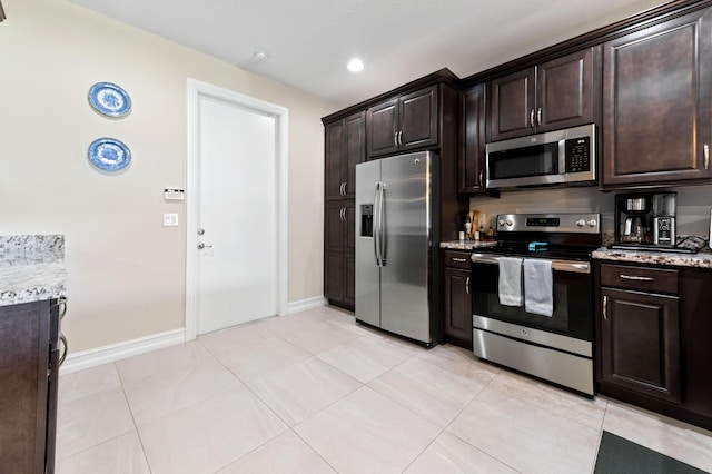 kitchen with appliances with stainless steel finishes, dark brown cabinets, light stone countertops, baseboards, and recessed lighting