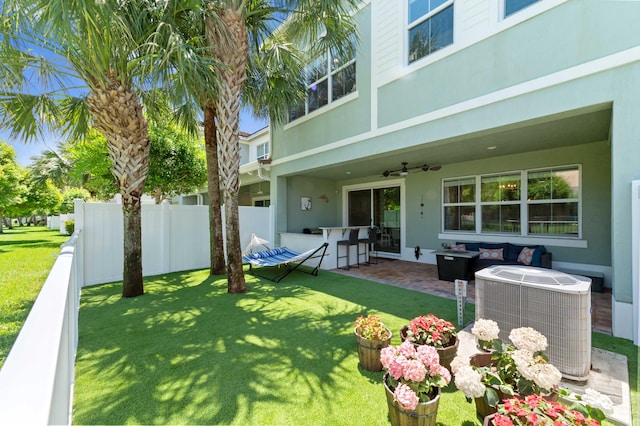 view of yard with a ceiling fan, central AC unit, and a patio area