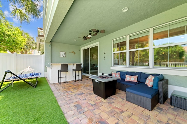 view of patio featuring fence and an outdoor living space with a fire pit