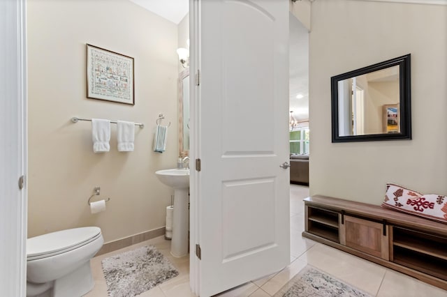 bathroom with tile patterned flooring, toilet, and baseboards