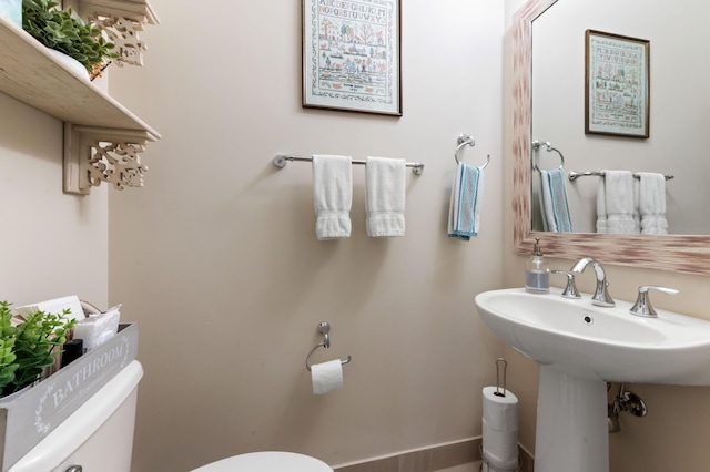 half bathroom featuring toilet and a sink