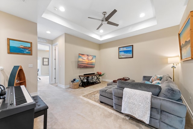 carpeted living room featuring a ceiling fan, recessed lighting, baseboards, and a raised ceiling