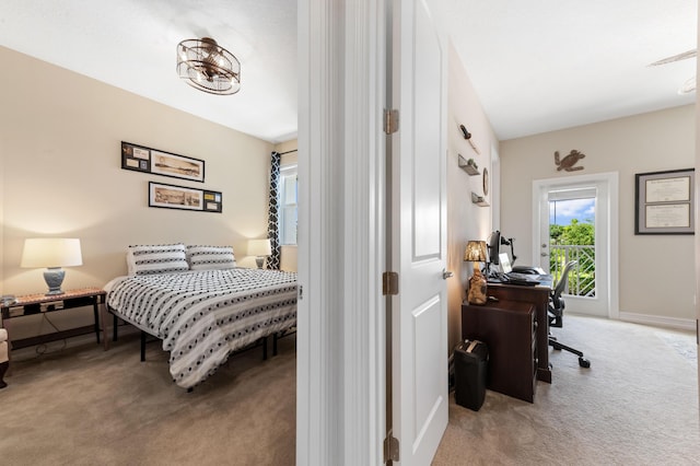 carpeted bedroom featuring a desk and baseboards