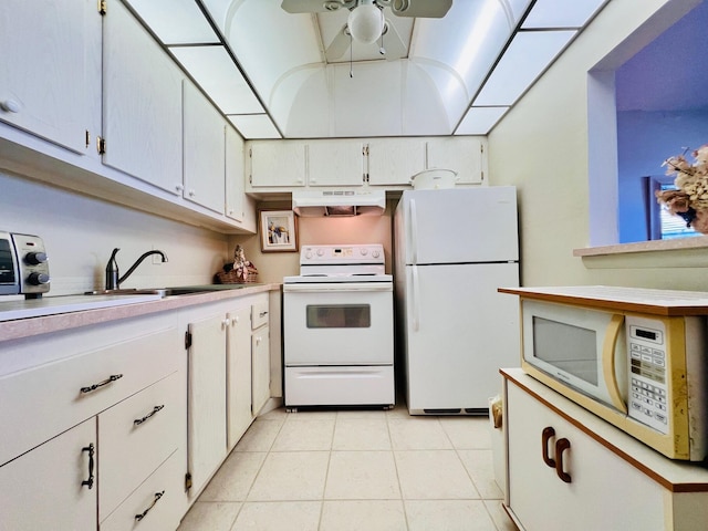 kitchen featuring white appliances, under cabinet range hood, a sink, and light countertops