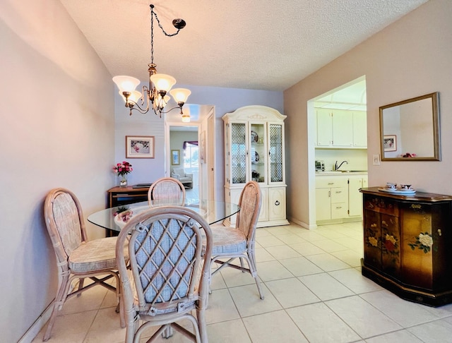 dining area featuring a chandelier, light tile patterned flooring, a textured ceiling, and baseboards