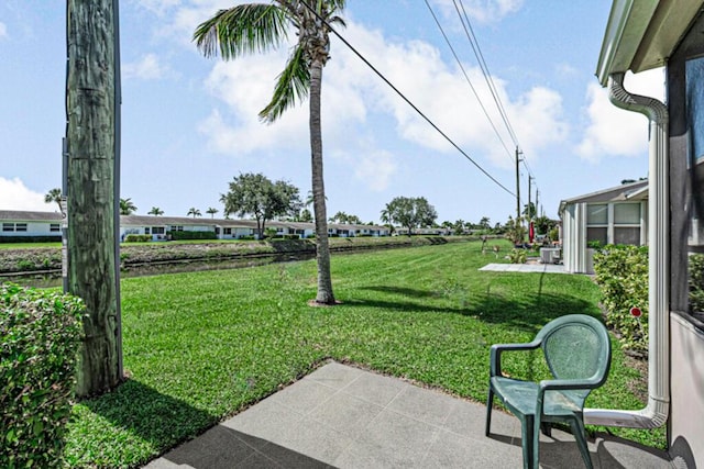 view of green lawn with a patio area