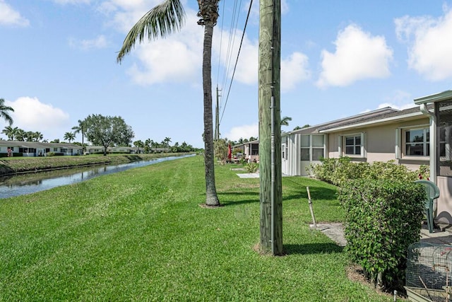 view of green lawn with a water view