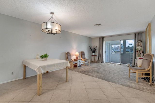 living area featuring a chandelier, baseboards, light tile patterned flooring, and a textured ceiling