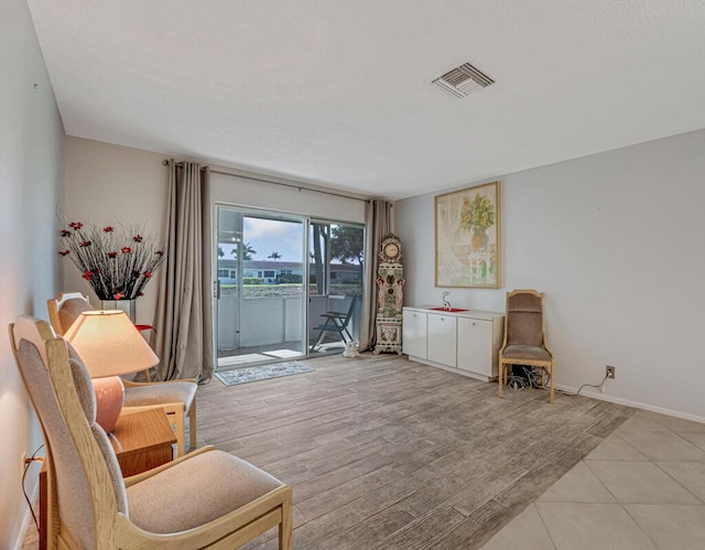 sitting room featuring baseboards and light wood-type flooring
