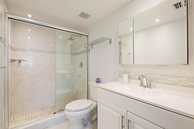 full bathroom with a shower stall, toilet, vanity, and tasteful backsplash