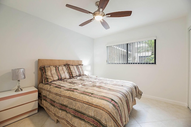 bedroom with light tile patterned flooring, baseboards, and a ceiling fan
