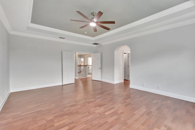 40 Country Lake Cir, Boynton Beach, FL 33436 - unfurnished room with a tray ceiling, arched walkways, ceiling fan, wood finished floors, and baseboards