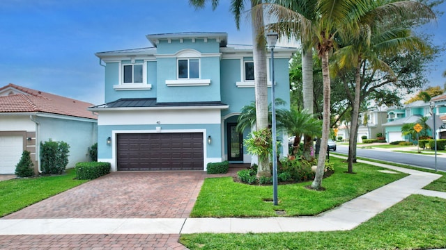 40 Country Lake Cir, Boynton Beach, FL 33436 - view of front of house featuring a standing seam roof, stucco siding, decorative driveway, an attached garage, and a front yard