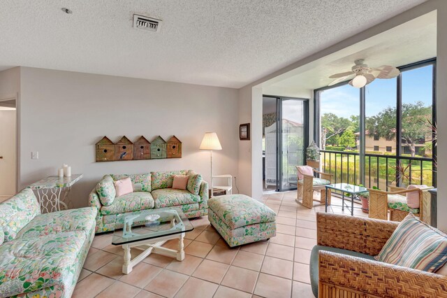 living room featuring light tile patterned floors, a ceiling fan, a textured ceiling, and floor to ceiling windows