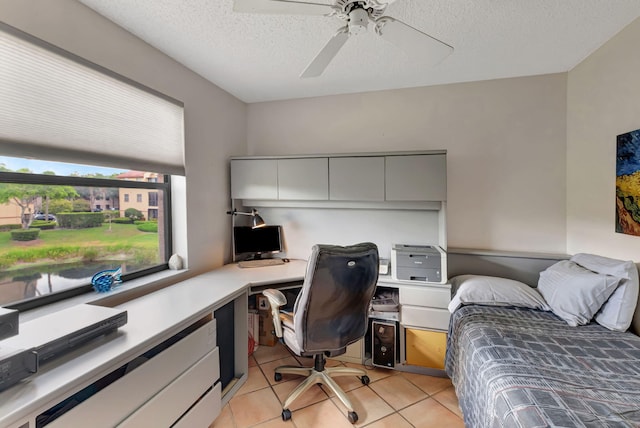 bedroom featuring a textured ceiling, a desk, light tile patterned floors, and ceiling fan