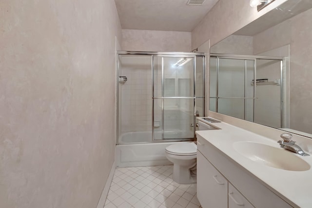 bathroom featuring tile patterned flooring, vanity, toilet, combined bath / shower with glass door, and baseboards
