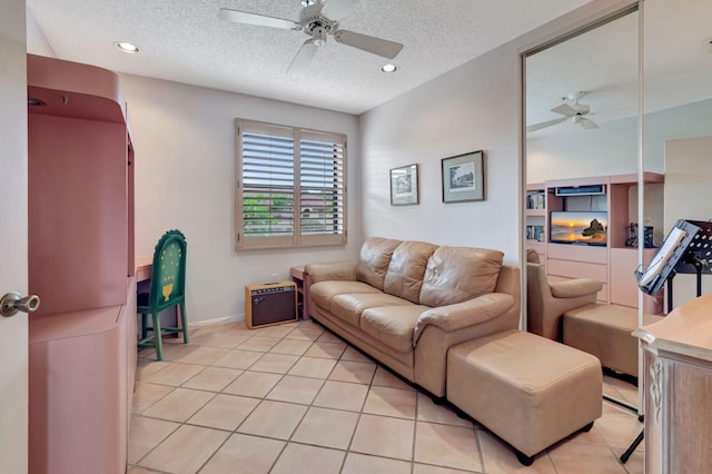 living room featuring a ceiling fan, light tile patterned floors, a textured ceiling, recessed lighting, and baseboards