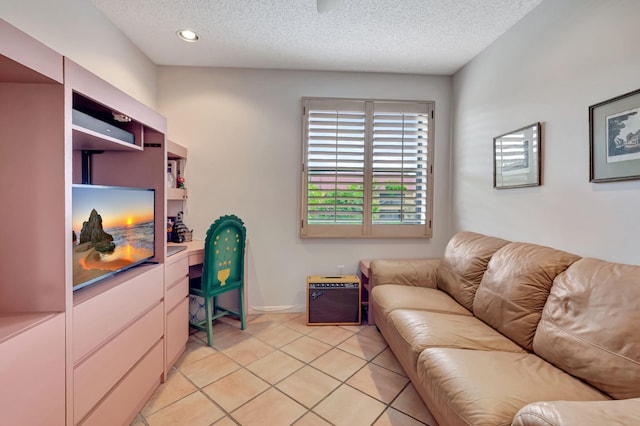 living room with a textured ceiling, light tile patterned flooring, and baseboards