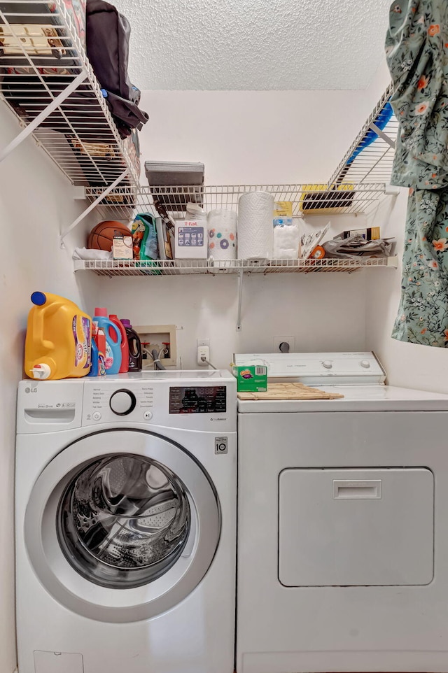 laundry room featuring washer and dryer and a textured ceiling