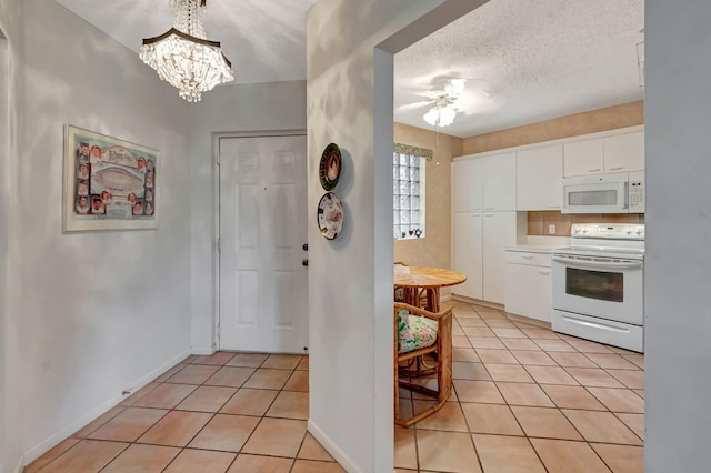 kitchen featuring white appliances, light tile patterned flooring, a chandelier, white cabinetry, and light countertops