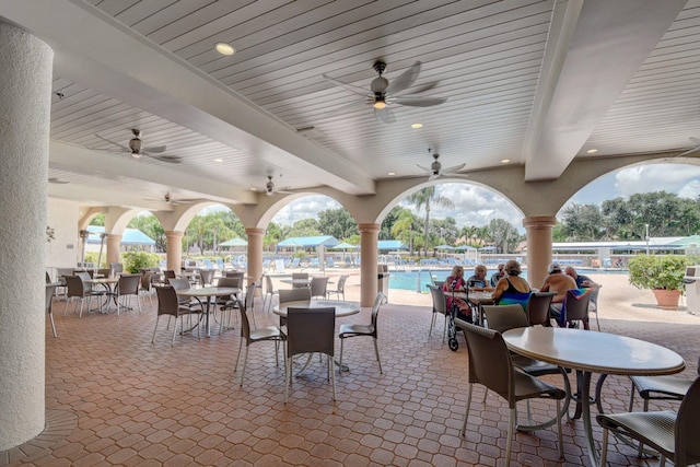 view of patio / terrace featuring a ceiling fan, outdoor dining area, and a community pool
