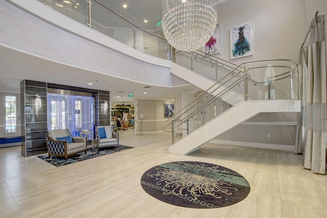 foyer entrance featuring stairway, baseboards, a chandelier, a high ceiling, and wood finished floors