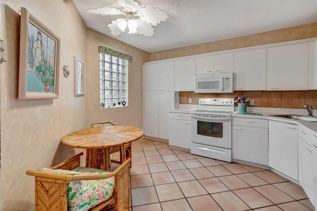 kitchen with white appliances, a sink, white cabinetry, light countertops, and a textured ceiling