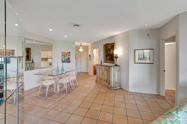 dining space featuring a textured ceiling, light tile patterned floors, and recessed lighting