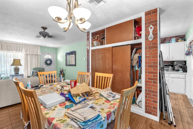 730 NE 23rd Pl, Pompano Beach, FL 33064 - dining area featuring a chandelier, ceiling fan, and light wood-style floors