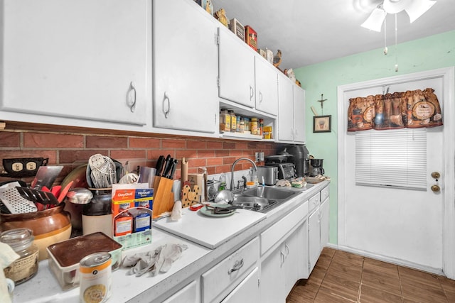 730 NE 23rd Pl, Pompano Beach, FL 33064 - kitchen featuring a sink, light countertops, a ceiling fan, white cabinets, and tasteful backsplash