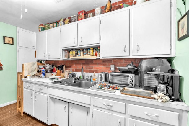 730 NE 23rd Pl, Pompano Beach, FL 33064 - kitchen with backsplash, light countertops, a sink, white cabinetry, and open shelves